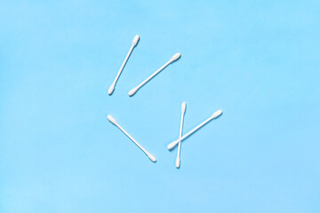 Cotton buds. White cotton swabs, top view. Cotton sticks isolated on blue background.