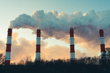 Air pollution by harmful emissions. Pipes with smoke on the background of a blue sk