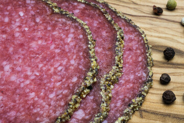 Makro closeup of isolated slices french fresh salami with mixed pepper crust and peppercorns on...