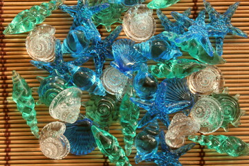 colorful glass shells and starfish on a background of bamboo sticks. top view
