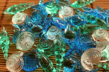 colorful glass shells and starfish on a background of bamboo sticks. top view