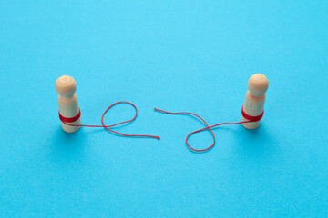 Divorce of a married couple. Two figures of people with a broken thread. Conflict concept.