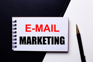 The words E-MAIL MARKETING written in red on a black and white background near the pen