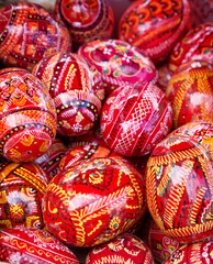 Bright painted eggs in wicker basket at market outdoors, easter holidays.