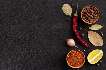 Obraz na płótnie Canvas Gourmet Food Ingredients: chilli, bay leaf, garlic, lemon, lime, allspice, a mix of aromatic spices. Food cooking concept. Flat lay with copy space. 