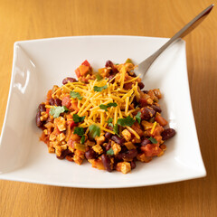 assiette de chili sin carne, plat sans viande, végétarien, sain recouvert de cheddar appétissant