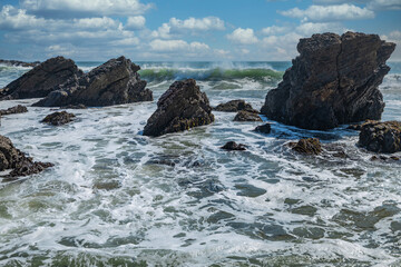 Fototapeta na wymiar Beautiful seascape of the Pacific coast in California, waves, rocks, sky, sun. Concept, perfect postcard and guide.