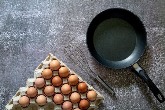 Still life with eggs and pan on wooden table, top view,Animal,Bread,Breakfast,Cholesterol,Circle,Close-up,Cooked,Cooking,Cooking Oil,Cooking Pan,Cutting Board,Drink,Egg,Egg Yolk,Farm,Food,Freshness,Fr