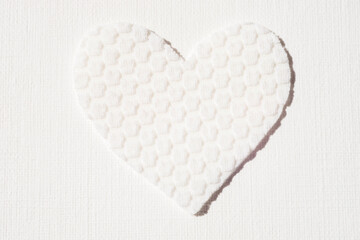 Cute white heart made of textured material on the table