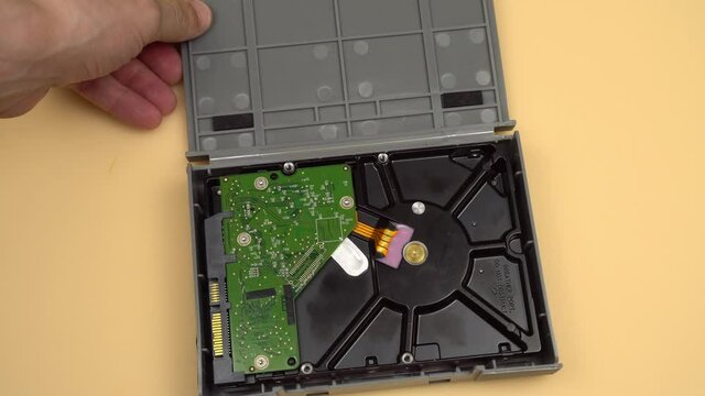 Men's hands open the gray shockproof case and take out the 3.5 HDD, then carefully put it back. The concept of data storage or archive. Important information. Demagnetization.