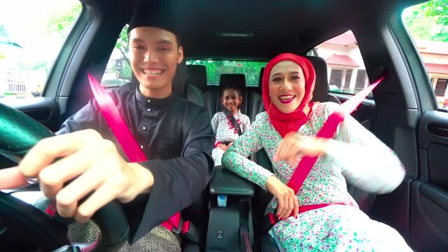 Malay family inside the car wearing traditional costume for Hari Raya festive