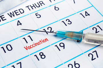 vaccine injection on calendar with vaccination reminder notation. Vaccination concept. syringe and...