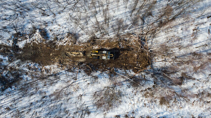 a tractor with machines in a forest in winter for cutting trees