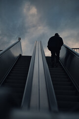 Mann auf Rolltreppe nach oben 