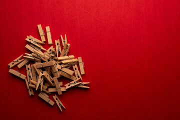 brown wooden clothespins, woden clips on red background