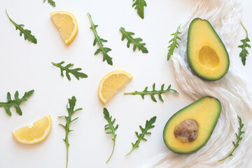Two avocado slices and lemon on a white napkin
