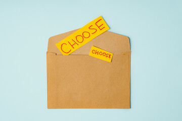 The inscription CHOOSE on yellow paper is on the envelope, the concept of choice and solutions