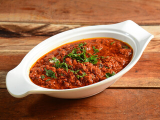 Chicken kheema made of indian spices served in a bowl over a wooden rustic background. selective focus