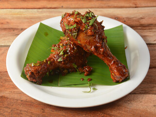 Tasty and spicy Chicken drumstick fry served on wooden background. Dishes and appetizers of indian cuisine, selective focus