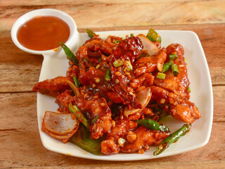 Assorted indian food Honey Chilli Chicken on wooden background. Dishes and appetizers of indian cuisine, selective focus