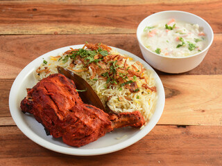 Tandoori chicken and Chicken Biryani served on rustic wooden background. Dishes and appetizers of indian cuisine, selective focus