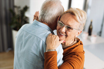 Happy mature couple having fun while dancing at home