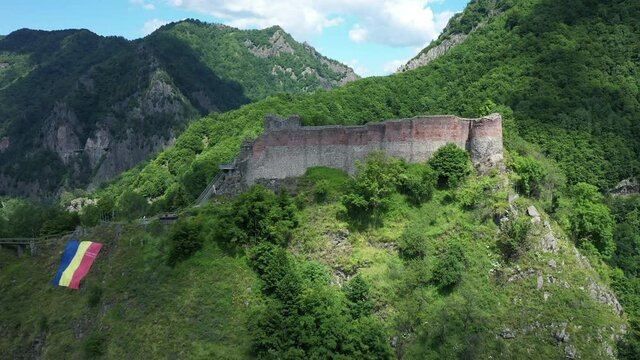 Mount Cetatea, Romania, 21.07.2019. Vlad Dracula Poenari Castle drone shot with Romanian Flag near Citadel, home of Vlad the Impaler and rest Basarab rulers, eastern europe travelling