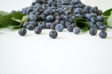 Fresh Blueberries in a bowl on white background. Juicy wild forest berries, bilberries. Fresh ripe blueberry with leaf isolated