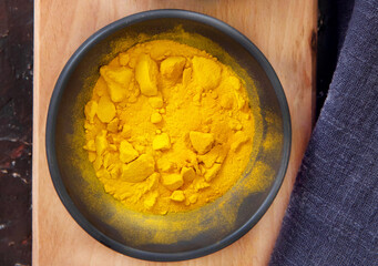 Turmeric powder on wooden background. Top view