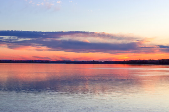 Panoramic view of a blue, pink and yellow sunset reflecting on the river © Karen Hogan