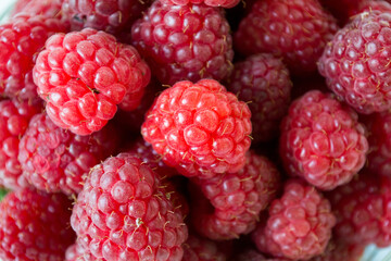Ripe raspberries with green leaf isolated on white background