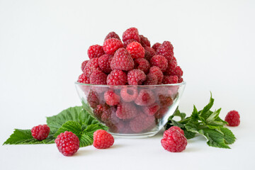 Ripe raspberries with green leaf isolated on white background