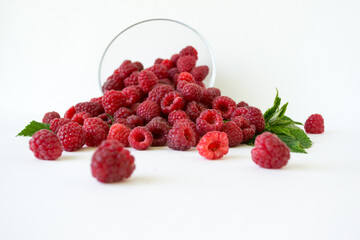 Ripe raspberries with green leaf isolated on white background