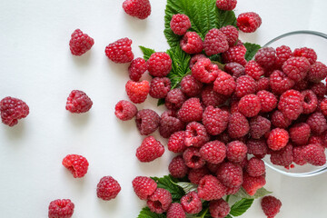 Ripe raspberries with green leaf isolated on white background