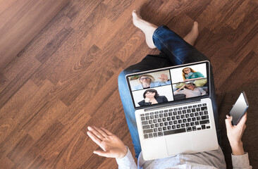 A woman sits on the floor with a laptop, communicates online via videoconference, call, webinar...