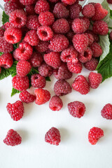 Ripe raspberries with green leaf isolated on white background