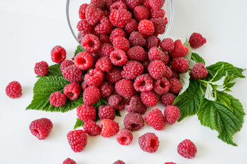 Ripe raspberries with green leaf isolated on white background