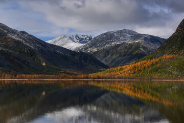 Calm on a mountain lake on a sunny autumn day