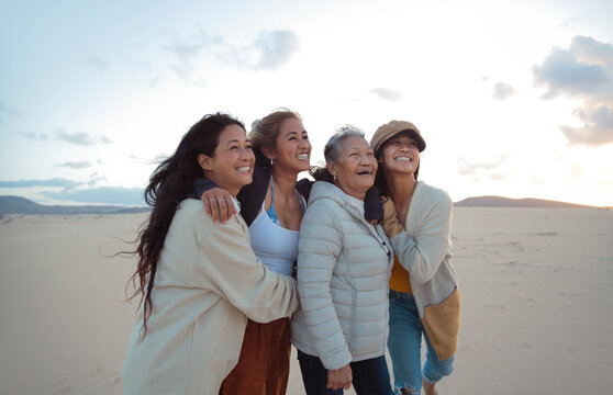 Family of four filipino women walking and hugging each other in a desert land - Beautiful women of different generations spending time together