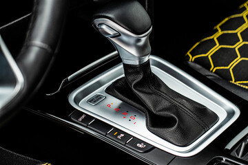 Close up of the automatic gearbox lever. Gear shift handle in a modern car. Modern car interior detail.