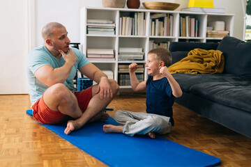 father and son workout training at home. quarantine concept.