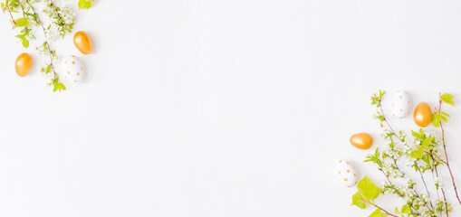 Flat lay easter composition with spring flowers and easter eggs on a white background