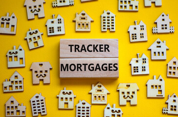 Tracker mortgage symbol. Concept words 'Tracker mortgage' on wooden blocks on a beautiful yellow backgrounds. Wooden models of house. Business, tracker mortgage concept.