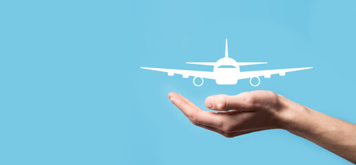 Male hand holding plane airplane icon on blue background. Banner.nline ticket purchase.Travel icons...