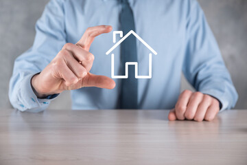 Real estate concept, businessman holding a house icon.House on Hand.Property insurance and security...