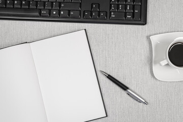 Livre ouvert sans inscription avec un café sur un espace de travail.