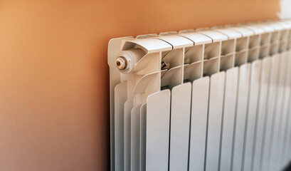 Close up of modern battery in room. White heating radiator indoor.