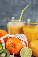 An orange wrapped with a measuring tape and a caliper surrounded by fresh fruits