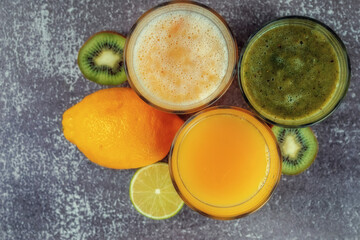 Top view of glasses of orange juice and banana kiwi and spinach smoothies