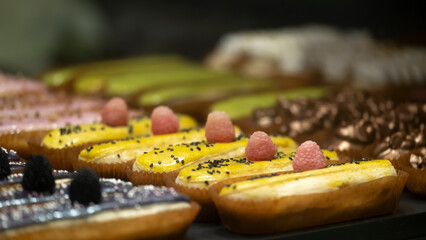 Delicious eclairs on the counter of the store.